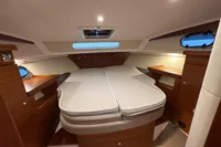 Interior cabin of 2019 Nimbus 365 Coupe, featuring a cozy bed and wooden furnishings.