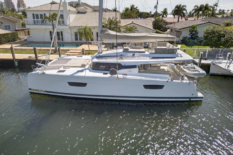 Lucky Dog Yacht Photos Pics 2022 Fountaine Pajot Tanna 47 catamaran docked by waterfront homes.