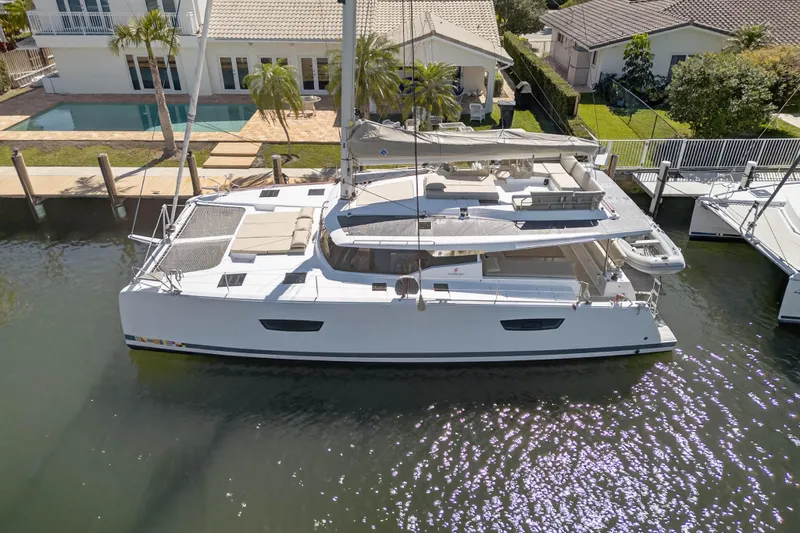 Lucky Dog Yacht Photos Pics 2022 Fountaine Pajot Tanna 47 catamaran docked by waterfront home.