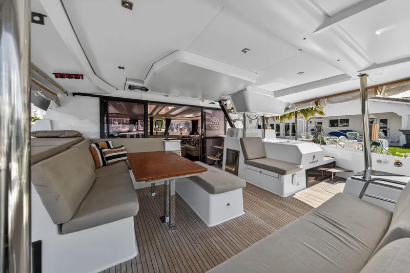 Lucky Dog Yacht Photos Pics Luxurious interior of 2022 Fountaine Pajot Tanna 47 catamaran with spacious seating and dining area.