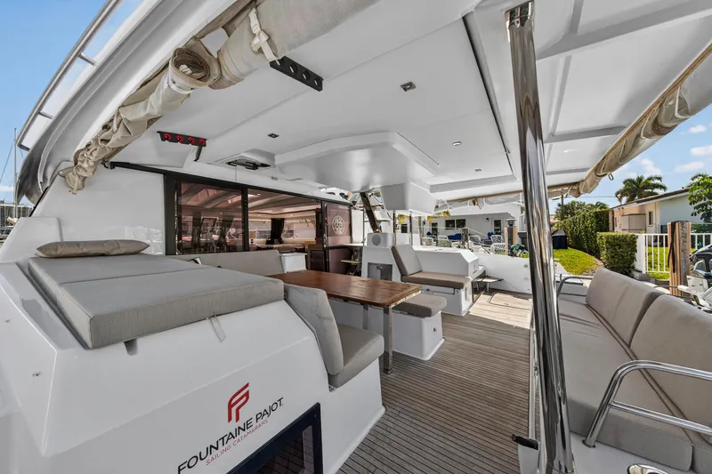 Lucky Dog Yacht Photos Pics Luxurious 2022 Fountaine Pajot Tanna 47 yacht deck with seating and dining area.