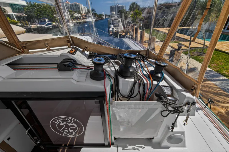 Lucky Dog Yacht Photos Pics 2022 Fountaine Pajot Tanna 47 yacht deck with winches and ropes, docked in a marina.