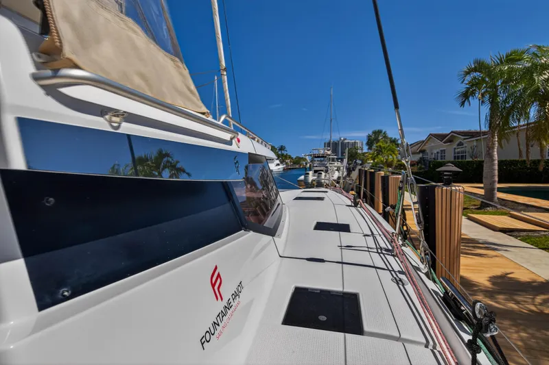 Lucky Dog Yacht Photos Pics 2022 Fountaine Pajot Tanna 47 catamaran docked, showcasing sleek design and modern features.