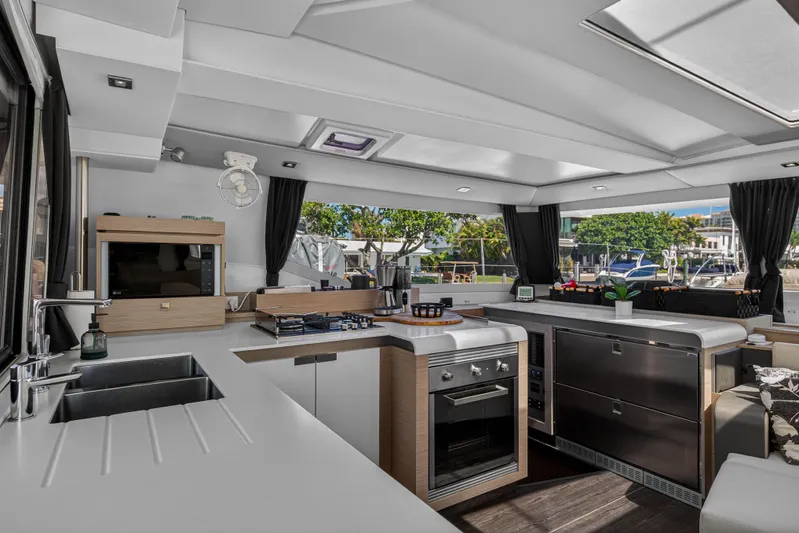 Lucky Dog Yacht Photos Pics Luxurious 2022 Fountaine Pajot Tanna 47 yacht interior with modern kitchen and sleek design.