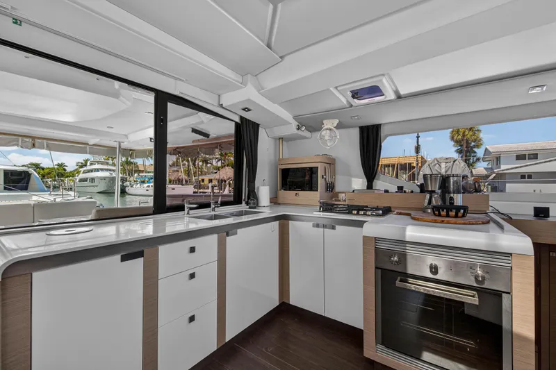 Lucky Dog Yacht Photos Pics Modern kitchen interior of 2022 Fountaine Pajot Tanna 47 yacht, featuring sleek design and appliances.