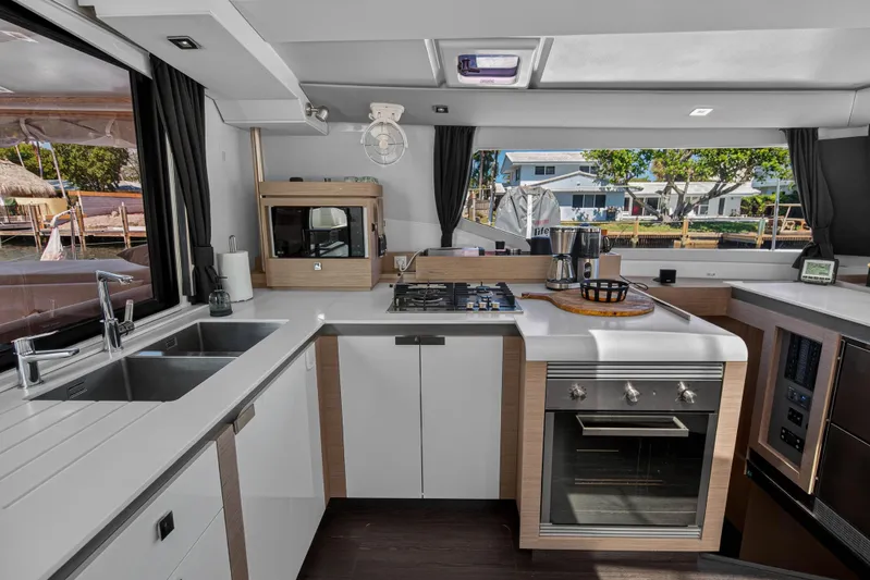 Lucky Dog Yacht Photos Pics Modern kitchen interior of 2022 Fountaine Pajot Tanna 47 yacht with sleek appliances.