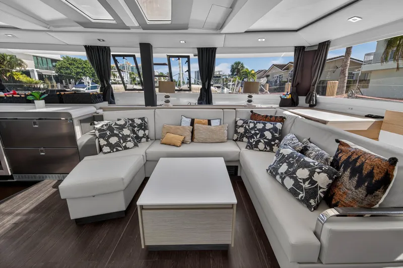 Lucky Dog Yacht Photos Pics Luxurious interior of 2022 Fountaine Pajot Tanna 47 catamaran with elegant seating and decor.