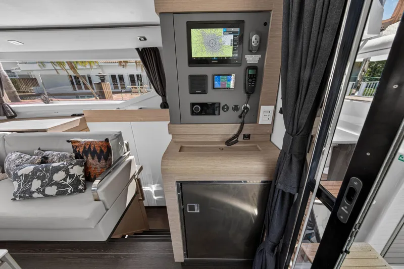 Lucky Dog Yacht Photos Pics 2022 Fountaine Pajot Tanna 47 yacht interior with navigation panel and cozy seating area.