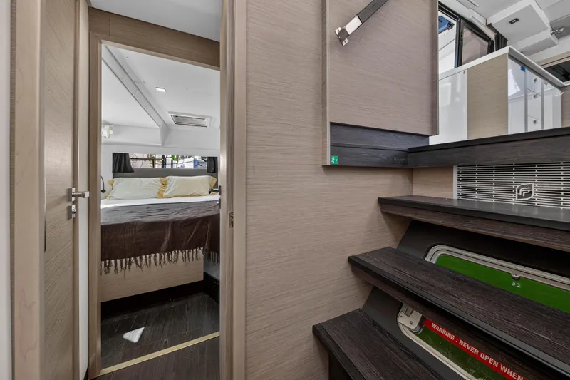 Lucky Dog Yacht Photos Pics Interior of 2022 Fountaine Pajot Tanna 47 yacht, featuring a cozy bedroom and modern staircase.