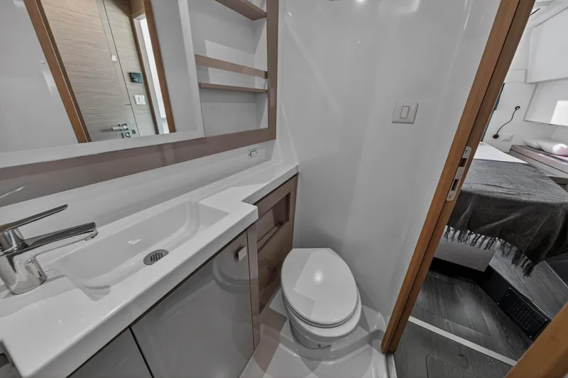 Lucky Dog Yacht Photos Pics Modern bathroom interior on 2022 Fountaine Pajot Tanna 47 yacht, featuring sleek sink and toilet.