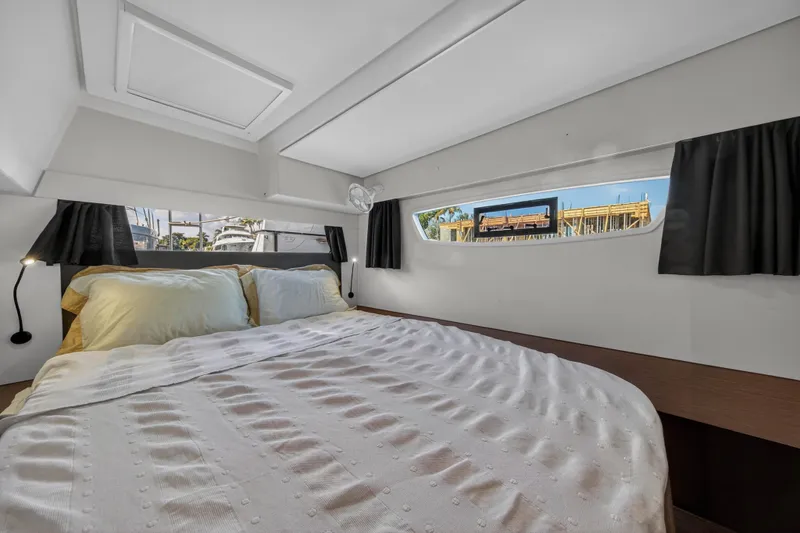 Lucky Dog Yacht Photos Pics Interior cabin of 2022 Fountaine Pajot Tanna 47 catamaran, featuring a cozy bed and windows.