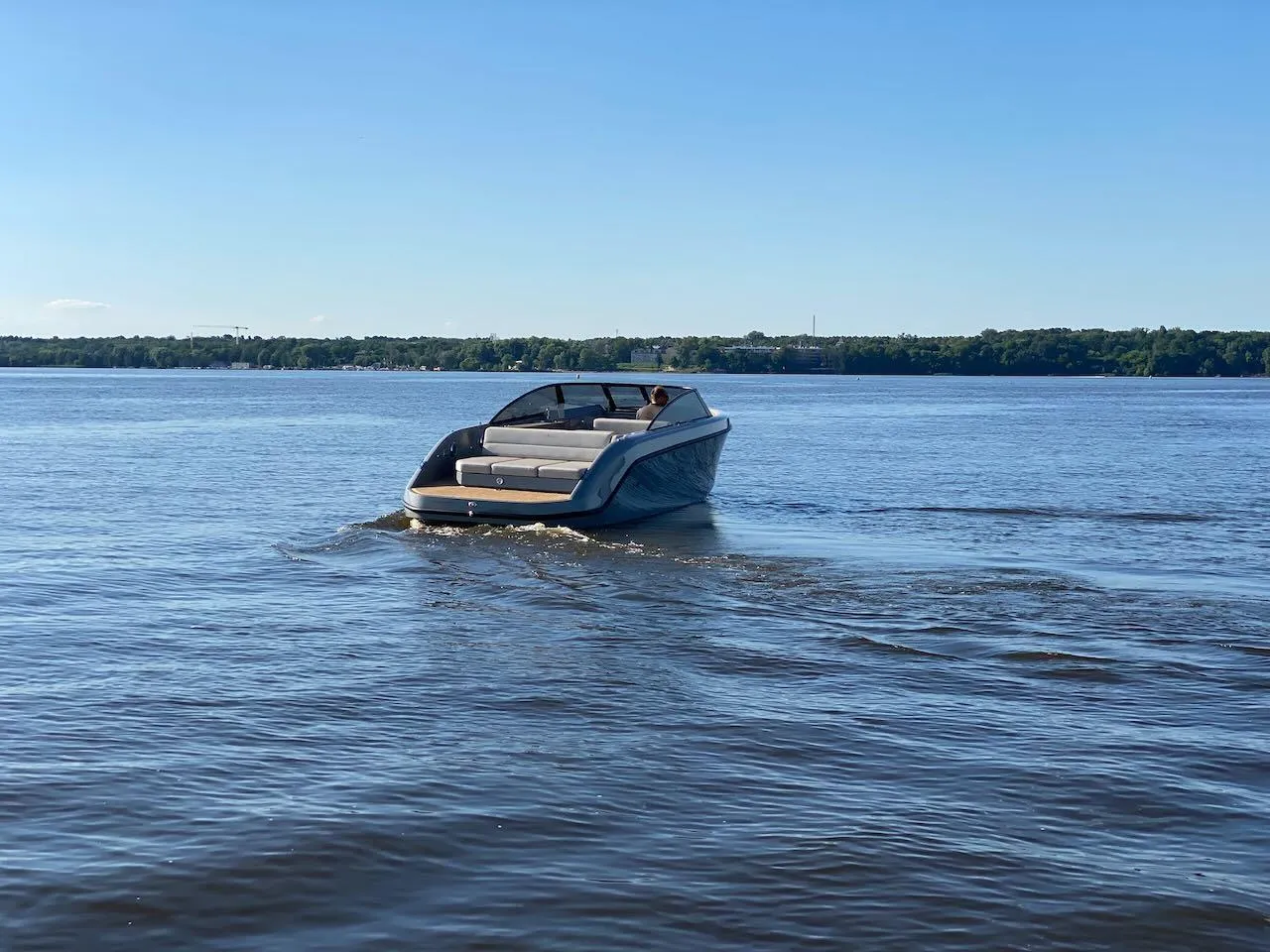 2021 Rand Leisure 28 boat cruising on a calm lake under a clear blue sky.