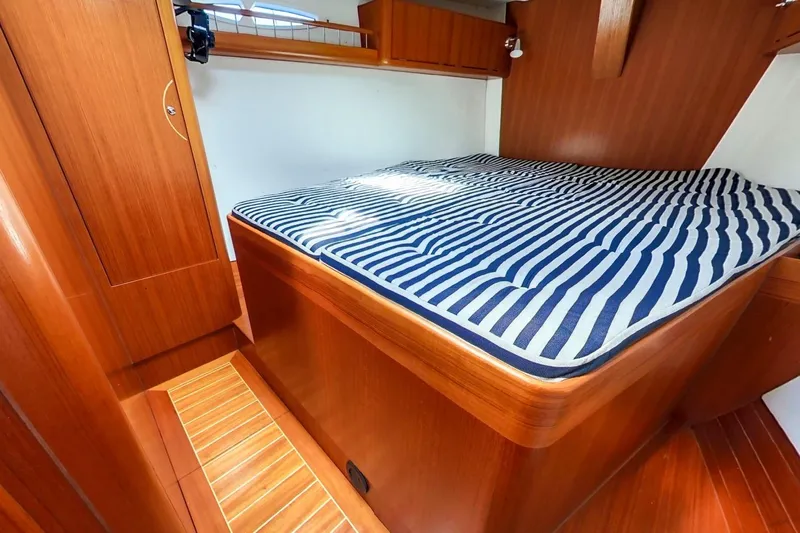  Yacht Photos Pics 2008 X-Yachts X50 cabin with striped bedding and wooden interior.