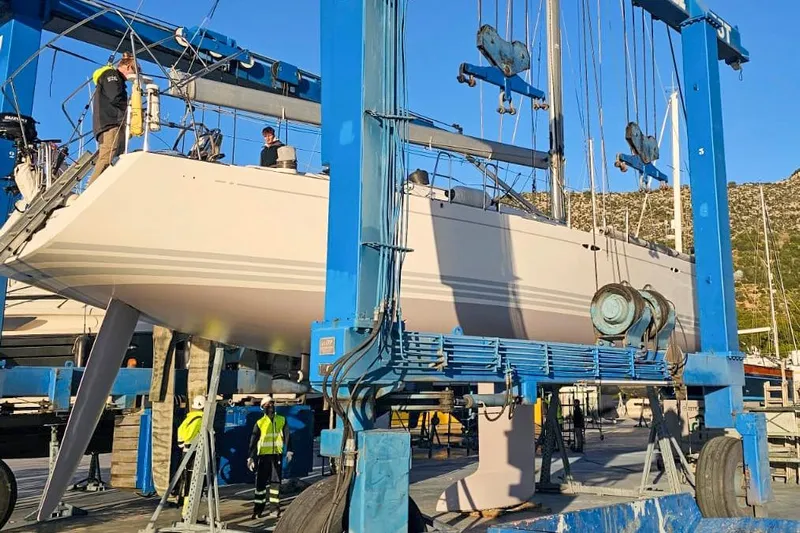  Yacht Photos Pics 2008 X-Yachts X50 sailboat being lifted by a blue crane in a shipyard.