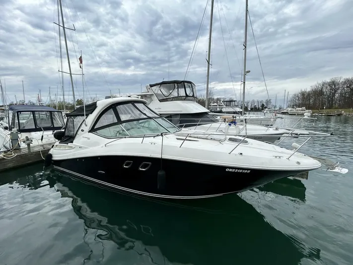  Yacht Photos Pics 2010 Sea Ray 330 Sundancer yacht docked in a marina under cloudy skies.