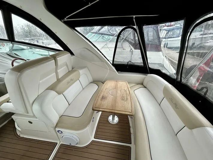  Yacht Photos Pics Interior of 2010 Sea Ray 330 Sundancer with white seating and wooden table.
