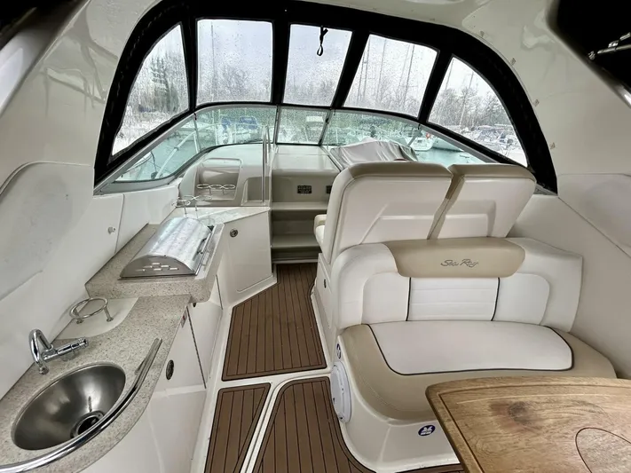  Yacht Photos Pics Interior of 2010 Sea Ray 330 Sundancer boat with seating, sink, and wooden flooring.