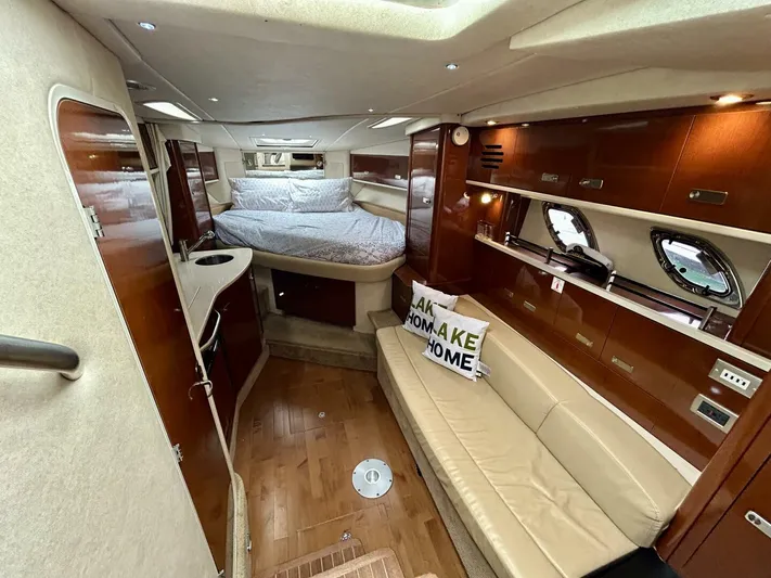  Yacht Photos Pics Interior of 2010 Sea Ray 330 Sundancer yacht with bed, sofa, and wooden cabinetry.