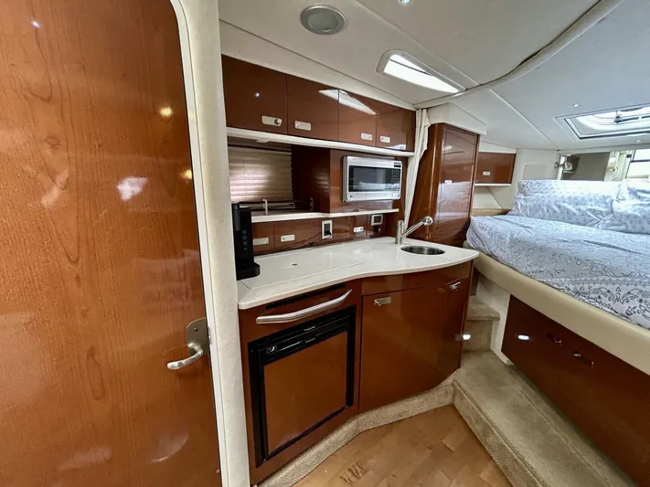  Yacht Photos Pics Interior of 2010 Sea Ray 330 Sundancer with kitchenette and cozy sleeping area.