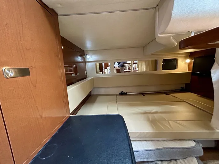  Yacht Photos Pics Interior cabin of 2010 Sea Ray 330 Sundancer, featuring wood paneling and cozy sleeping area.