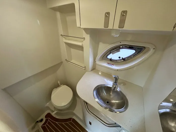  Yacht Photos Pics 2010 Sea Ray 330 Sundancer bathroom with sink, toilet, and porthole window.