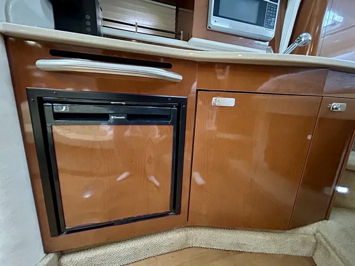  Yacht Photos Pics 2010 Sea Ray 330 Sundancer kitchen with wood cabinetry, mini fridge, and microwave.