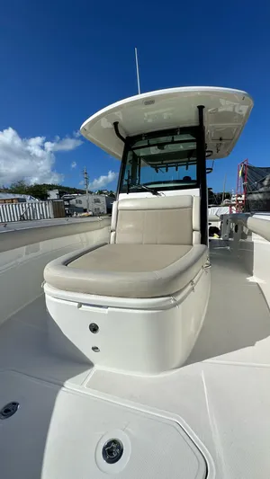  Yacht Photos Pics 2022 Boston Whaler 330 Outrage boat with sleek design and comfortable seating under a clear blue sky.