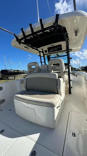  Yacht Photos Pics 2022 Boston Whaler 330 Outrage boat interior with seating and console under blue sky.