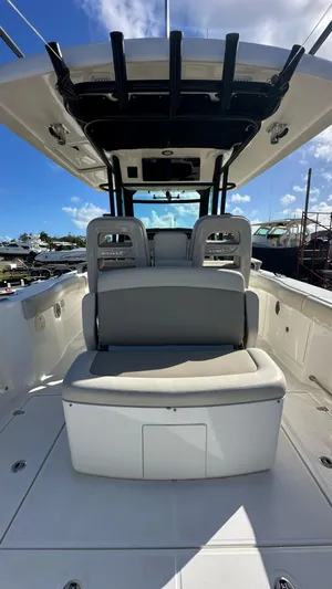  Yacht Photos Pics 2022 Boston Whaler 330 Outrage boat interior with seating and helm under clear blue sky.