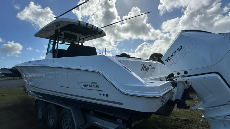  Yacht Photos Pics 2022 Boston Whaler 330 Outrage boat with triple-axle trailer and powerful outboard engines.