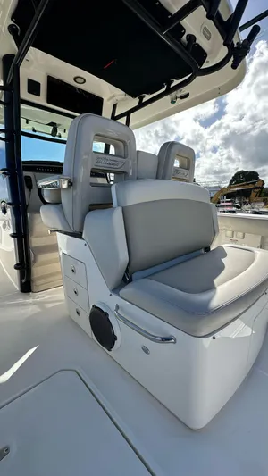  Yacht Photos Pics 2022 Boston Whaler 330 Outrage boat interior with cushioned seating and storage compartments.