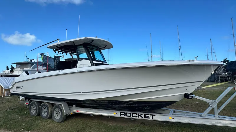  Yacht Photos Pics 2022 Boston Whaler 330 Outrage boat on a trailer, clear sky background.