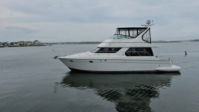  Yacht Photos Pics 2000 Carver 450 Voyager Pilothouse yacht on calm water, overcast sky.