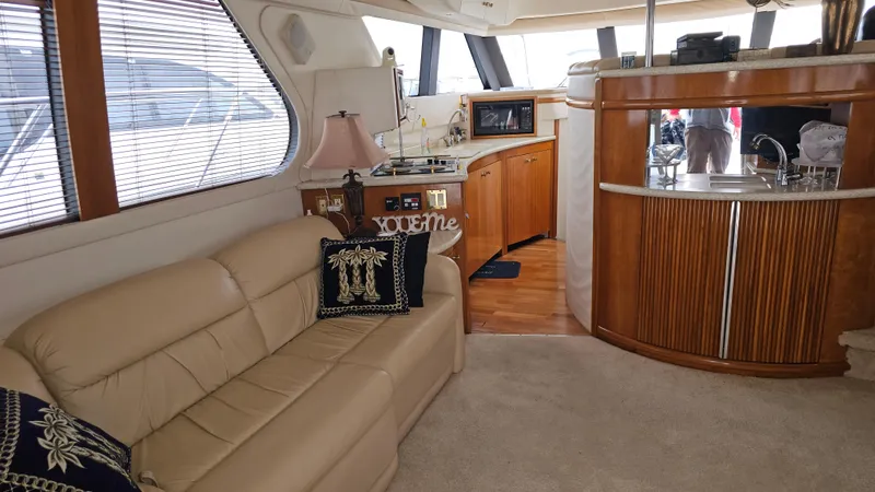  Yacht Photos Pics Interior of 2000 Carver 450 Voyager Pilothouse with beige sofa and wooden cabinetry.