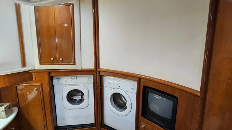  Yacht Photos Pics Laundry area in 2000 Carver 450 Voyager Pilothouse with washer, dryer, and TV.