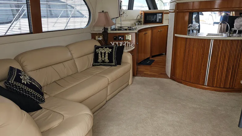  Yacht Photos Pics Interior of 2000 Carver 450 Voyager Pilothouse with beige leather sofa and wooden cabinetry.