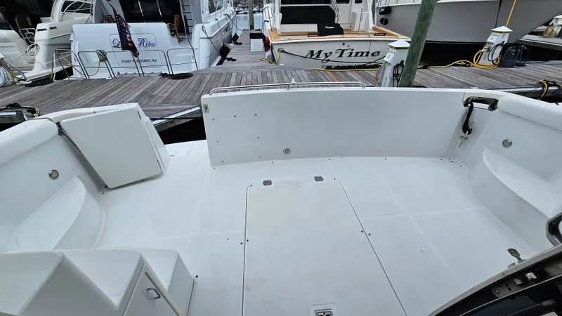  Yacht Photos Pics 2000 Carver 450 Voyager Pilothouse boat deck at marina, featuring spacious seating area.