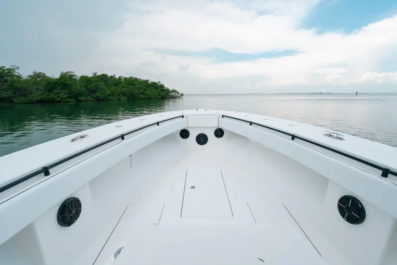 Yacht Photos Pics Bow view of 2013 SeaHunter 45 boat on calm water near lush island.