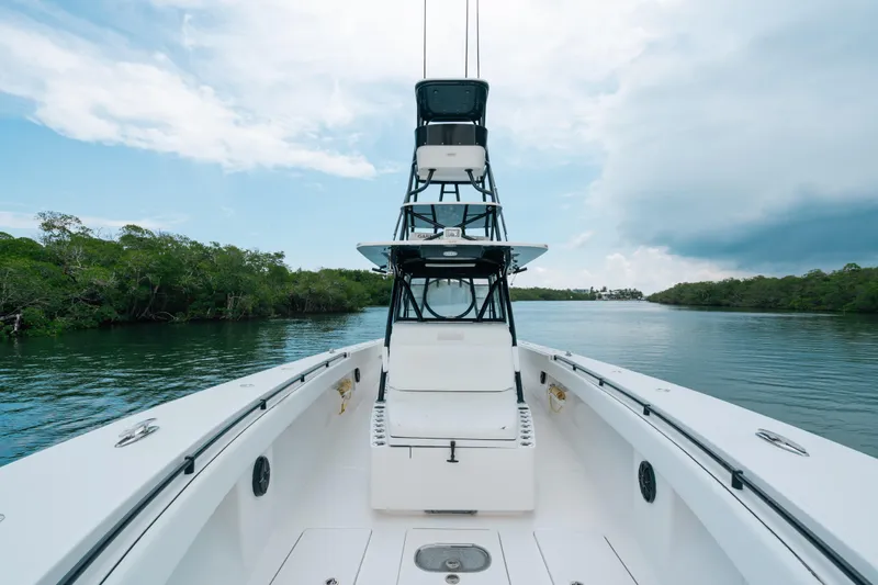  Yacht Photos Pics 2013 SeaHunter 45 boat on calm water, surrounded by lush greenery and cloudy sky.