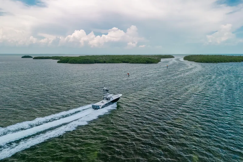  Yacht Photos Pics SeaHunter 45 boat cruising through open water, 2013 model, with lush islands in the background.