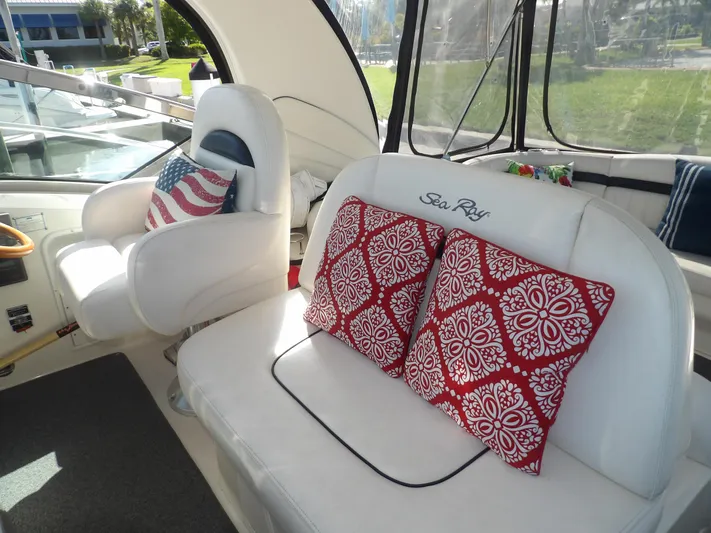Parrotdise Yacht Photos Pics Interior seating of 2005 Sea Ray 390 Sundancer with red patterned pillows and American flag cushion.