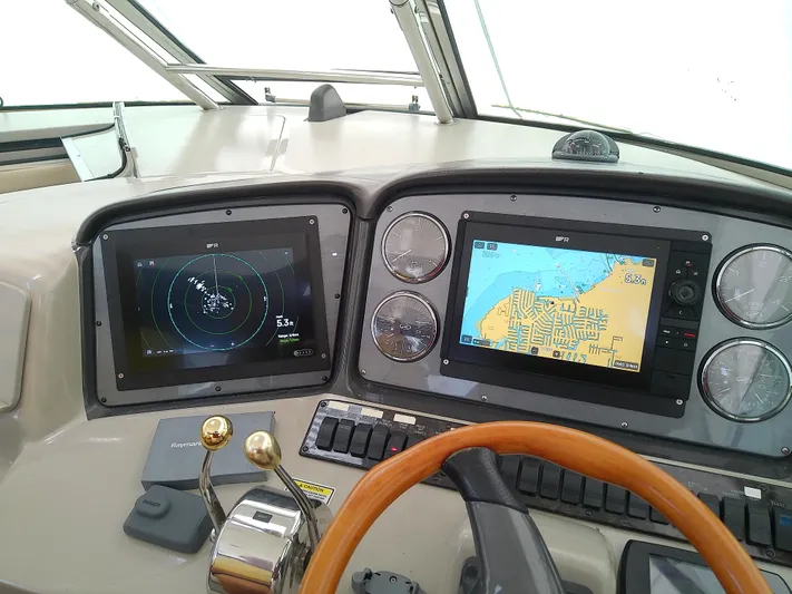Parrotdise Yacht Photos Pics Control panel of a 2005 Sea Ray 390 Sundancer with navigation screens and steering wheel.
