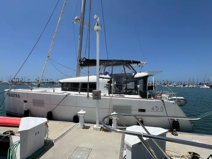 Celestra Yacht Photos Pics 2017 Lagoon 400 S2 catamaran docked at marina under clear blue sky.