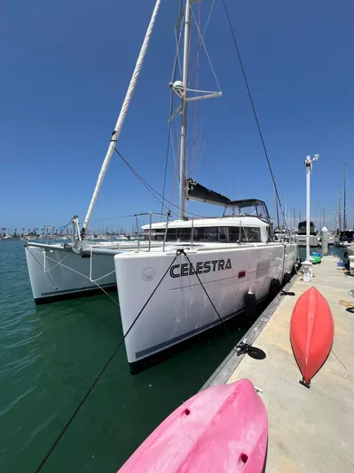 Celestra Yacht Photos Pics 2017 Lagoon 400 S2 catamaran docked at marina with kayaks nearby.