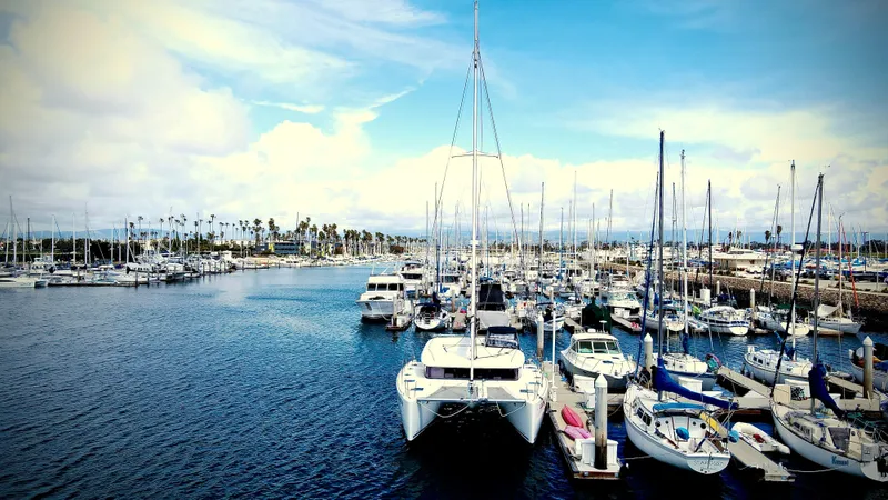 Celestra Yacht Photos Pics Marina with various boats, featuring a 2017 Lagoon 400 S2 catamaran under a bright blue sky.
