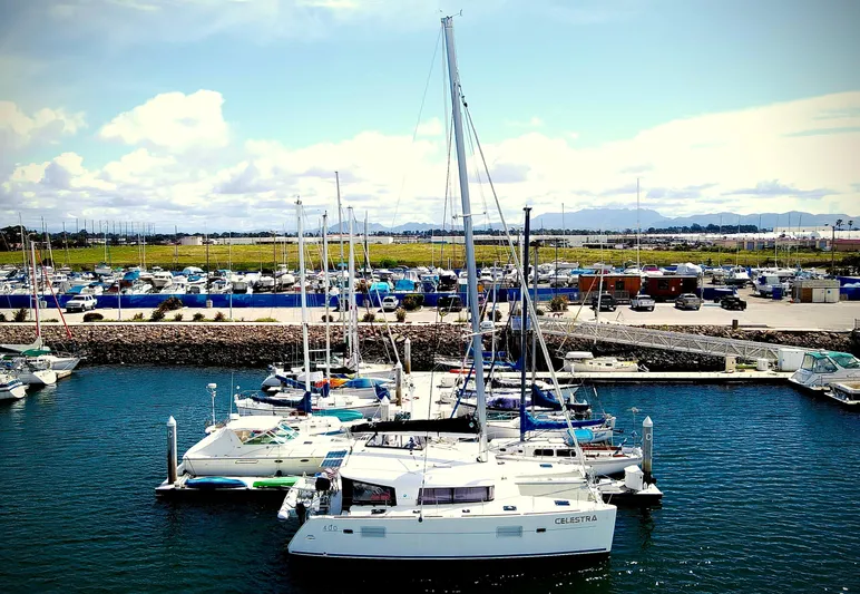 Celestra Yacht Photos Pics 2017 Lagoon 400 S2 catamaran docked in a marina with other boats.