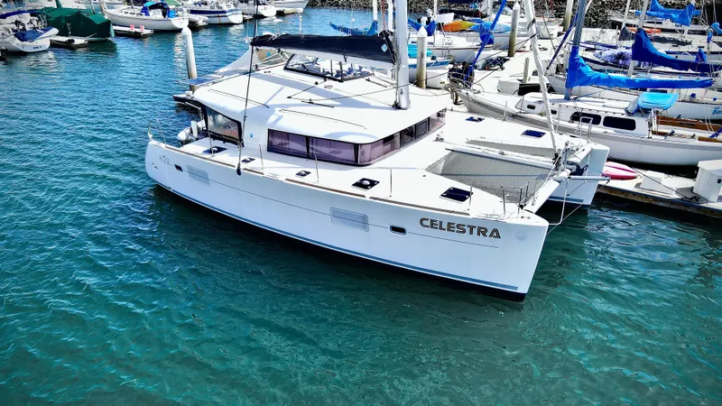 Celestra Yacht Photos Pics 2017 Lagoon 400 S2 catamaran docked in a marina, surrounded by other boats.