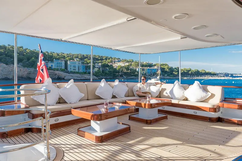  Yacht Photos Pics Luxurious 1995 Cantieri Navali Nicolini 43 yacht deck with seating, ocean view, and flag.