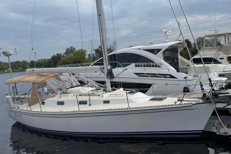 Pelican Yacht Photos Pics 2007 Tartan 3400 sailboat docked beside luxury yachts on a calm day.