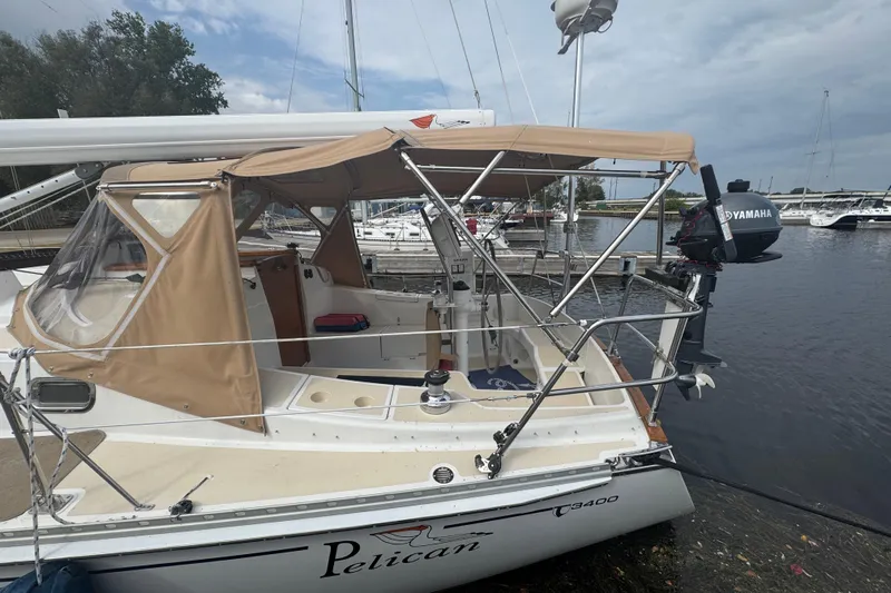 Pelican Yacht Photos Pics 2007 Tartan 3400 sailboat docked, featuring tan canopy and Yamaha outboard motor.